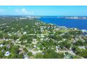 Wide aerial view showcasing a neighborhood near a body of water with lush green surroundings at 104 24Th Ne St, Bradenton, FL 34208