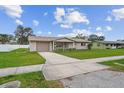 Tan single story house with attached garage and neatly landscaped yard at 1215 E Venice Ave, Venice, FL 34285