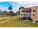 Condo building exterior with grassy area and road at 1330 Glen Oaks E Dr # 268D, Sarasota, FL 34232