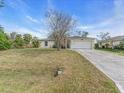 Single-story home on a grassy lot with a driveway leading to an attached two-car garage at 1382 Ronald St, North Port, FL 34286