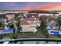 Waterfront property showcasing a large pool and beautiful sunset at 1389 Tangier Way, Sarasota, FL 34239