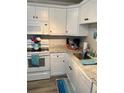 White kitchen with granite counters, stainless appliances, and wood flooring at 1603 Gulf N Dr # 27, Bradenton Beach, FL 34217