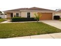 One-story home with a brown roof, attached garage, and neatly landscaped front yard at 206 65Th E Ave, Bradenton, FL 34203