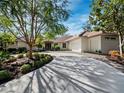 Stunning curb appeal featuring a circular driveway and lush landscaping at 3178 Dick Wilson Dr, Sarasota, FL 34240