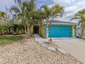 Front view of a yellow house with teal garage door and palm trees at 3972 Titan St, North Port, FL 34286