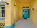 Teal front door entryway with yellow walls and decorative accents at 3972 Titan St, North Port, FL 34286