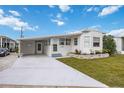 Front view of a white mobile home with carport, landscaping, and driveway at 4953 Sea Island Ave, Sarasota, FL 34234