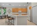 Spacious kitchen with light wood cabinets and island at 5351 Laurel Oak Ct, North Port, FL 34287