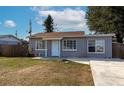 Gray house with a fenced yard, driveway, and mature trees at 5806 15Th W St, Bradenton, FL 34207
