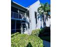 Side view of a light blue condo building with balcony and lush landscaping at 6707 Stone River Rd # 203, Bradenton, FL 34203