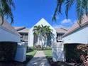 Front entrance and walkway of a light blue condo building with palm trees at 6707 Stone River Rd # 203, Bradenton, FL 34203