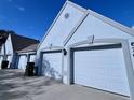 Row of attached garages with white doors in a light blue building at 6707 Stone River Rd # 203, Bradenton, FL 34203