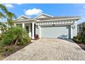 House exterior featuring a light gray color, paver driveway, and landscaping at 8725 Sundance Loop, Sarasota, FL 34238