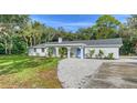 Newly renovated home exterior boasts a fresh white facade and landscaping at 1411 Quail Dr, Sarasota, FL 34231