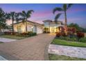 Two-story house with a paver driveway and palm trees at 16003 Kendleshire Ter, Lakewood Ranch, FL 34202