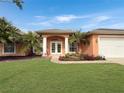 Attractive home with double doors and a neatly landscaped yard at 25072 Palisade Rd, Punta Gorda, FL 33983