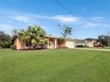A charming house with palm trees and a lush green lawn at 25072 Palisade Rd, Punta Gorda, FL 33983