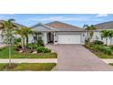 Beautiful home with landscaped yard, paver driveway, and two-car garage at 26017 Seastone Dr, Englewood, FL 34223