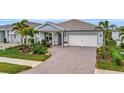 Single-Gathering home with a paver driveway and tropical landscaping at 26017 Seastone Dr, Englewood, FL 34223