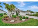 Charming house with a nicely landscaped front yard and palm trees at 26017 Seastone Dr, Englewood, FL 34223