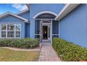 Inviting entryway with a screened door and well-manicured landscaping at 305 Coral Rd, Venice, FL 34293