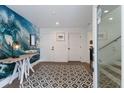Bright entryway with ocean-themed wall art, geometric tile flooring, and white doors at 6605 Gulf Dr, Holmes Beach, FL 34217