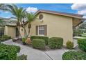 Side view of a house showcasing its light-yellow exterior and landscaping at 7146 Lakeside Dr, Sarasota, FL 34243
