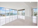 Bright living room with expansive windows and water views at 111 Golden Gate Pt # 701Ph, Sarasota, FL 34236