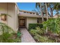 Welcoming entryway with a brick walkway, lush greenery, and a modern door at 1225 S View Dr, Sarasota, FL 34242