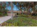 Single-story home with attractive landscaping and a brick driveway at 1225 S View Dr, Sarasota, FL 34242