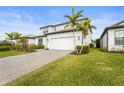 Two-story house with white garage door, palm trees, and brick driveway at 12409 Wigeon Dr, Bradenton, FL 34212