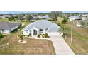 White house with gray roof, driveway, and landscaped yard in a residential area at 2053 Rio De Janeiro Ave, Punta Gorda, FL 33983