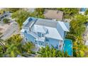 Elevated view showcasing a blue home, private pool, and rooftop deck at 2213 Avenue B, Bradenton Beach, FL 34217