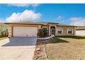 Tan house with white garage door and landscaping at 22419 Bette Ave, Port Charlotte, FL 33954