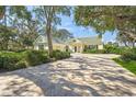 Bright yellow house with a large driveway and manicured lawn at 227 Saint James Park, Osprey, FL 34229