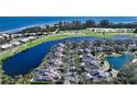 Aerial view showcasing a community of homes near a golf course and body of water at 3465 Winding Oaks Dr # 33, Longboat Key, FL 34228