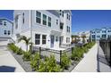 Gray paved pathway beside a light blue home with a black fence and landscaping at 407 Gowdy Rd, Sarasota, FL 34237