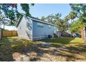 House's back with a grassy yard, wooden fence, and AC unit at 412 30Th E St, Palmetto, FL 34221