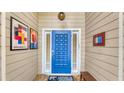 Inviting entryway with a vibrant blue door and unique wall art at 4372 Woodmans Chart # 143, Sarasota, FL 34235