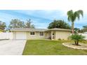 Newly remodeled light beige home with circular driveway and manicured lawn at 5425 Skyline Pl, Sarasota, FL 34232