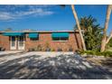 Brick house with teal awnings and a paved driveway at 713 Saint Judes S Dr # 2, Longboat Key, FL 34228