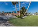 Landscaped yard with brick house and palm trees at 713 Saint Judes S Dr # 2, Longboat Key, FL 34228