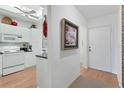 White kitchen with appliances and view into adjacent hallway at 9630 Club South Cir # 6207, Sarasota, FL 34238