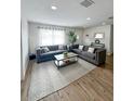 Spacious living room featuring hardwood floors and comfortable gray sofas at 1109 Harbor Blvd, Port Charlotte, FL 33952