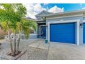 Front entry and blue garage doors of a house with palm trees at 12219 23Rd E St, Parrish, FL 34219