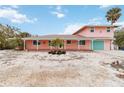 Pink two-story house with teal garage door and porch at 128 51St St # A, Holmes Beach, FL 34217