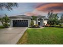 Gray house with black garage door and manicured lawn at 1604 21St W Ave, Palmetto, FL 34221