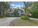 Two-story house with gray siding, paver driveway, and landscaping at 1702 Spoonbill Dr, Nokomis, FL 34275