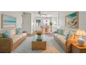 Inviting living area with wicker sofas, coastal artwork, and an adjacent dining space at 1853 Restful Dr # L2, Bradenton, FL 34207
