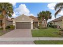 Single story house with brown garage door and palm trees at 19256 Jalisca St, Venice, FL 34293